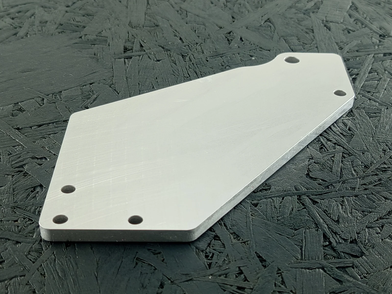 CNC-gefräster Halter aus Aluminium 5083, 6mm dick, mit Bohrungen und abgerundeten Kanten, auf dunklem Hintergrund.