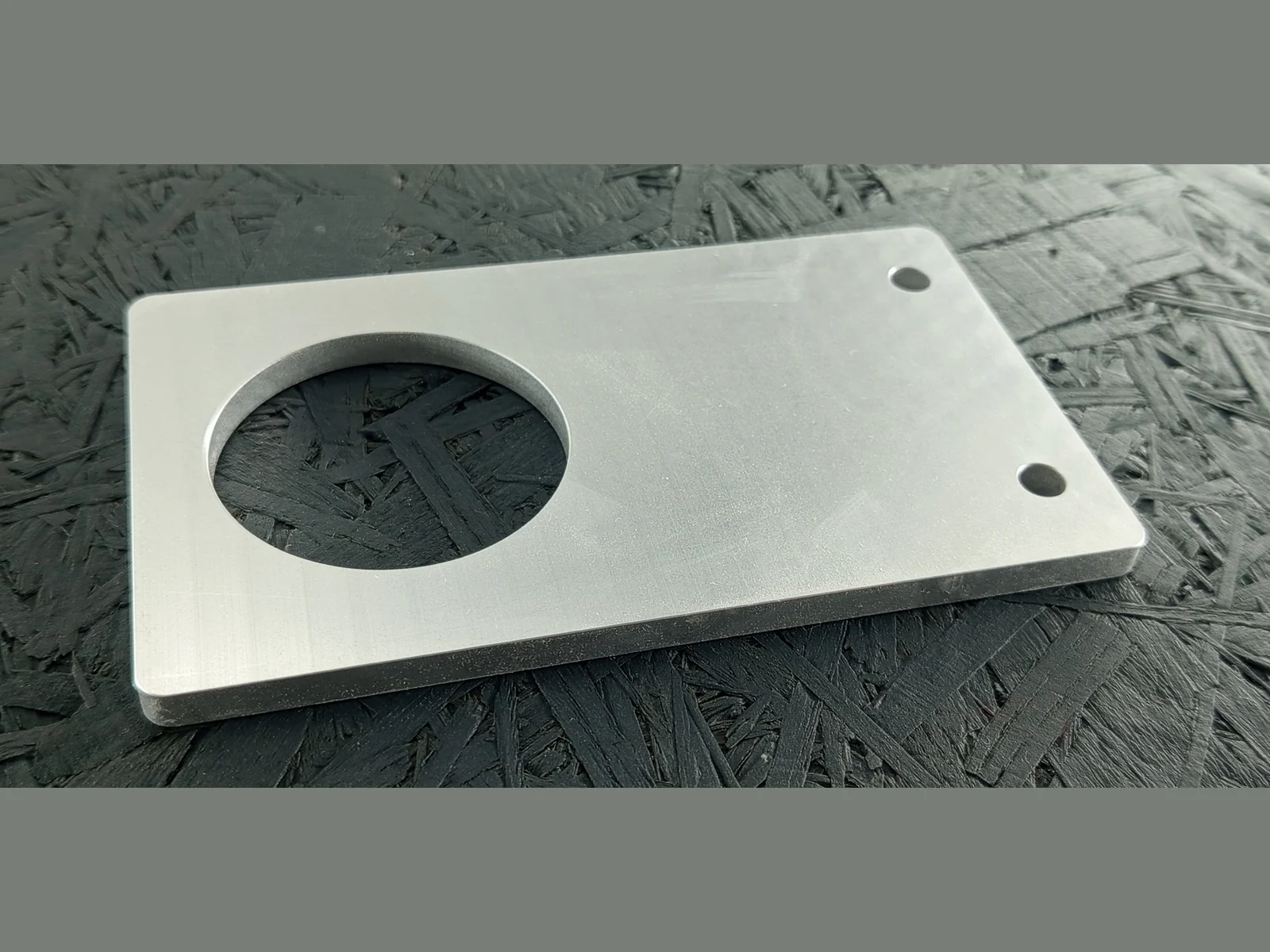 CNC-gefräster Halter aus Aluminium 5083, 6mm dick, mit großer runder Aussparung und zwei Bohrungen.