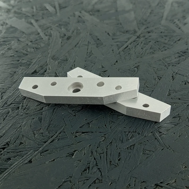 Zwei CNC-gefräste Flansche aus Aluminium 5083, 8mm dick, mit Bohrungen und Tasche, auf dunklem Hintergrund.