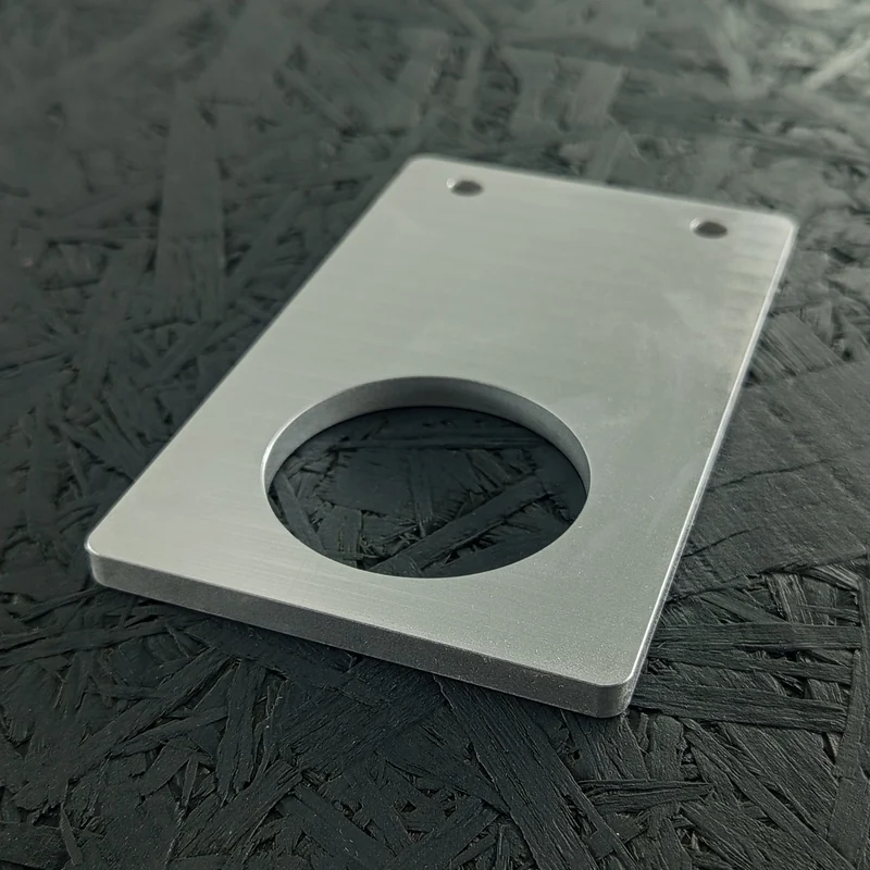 CNC-gefräster Halter aus Aluminium 5083, 6mm dick, mit großer runder Aussparung und zwei Bohrungen.