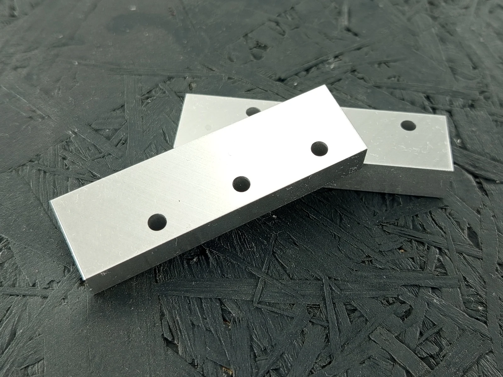 Zwei CNC-gefräste Halter aus Aluminium 5083, 10mm dick, mit drei Bohrungen pro Teil.