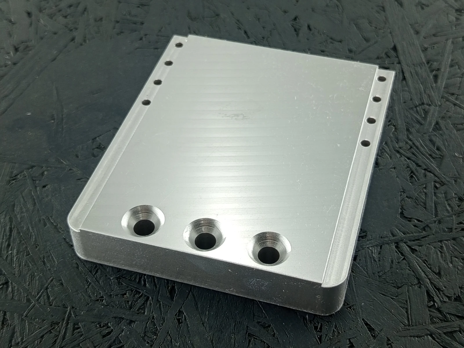 CNC-gefrästes Maschinenbauteil aus Alu 7075, 20mm dick, mit Senkungen und Bohrungen.