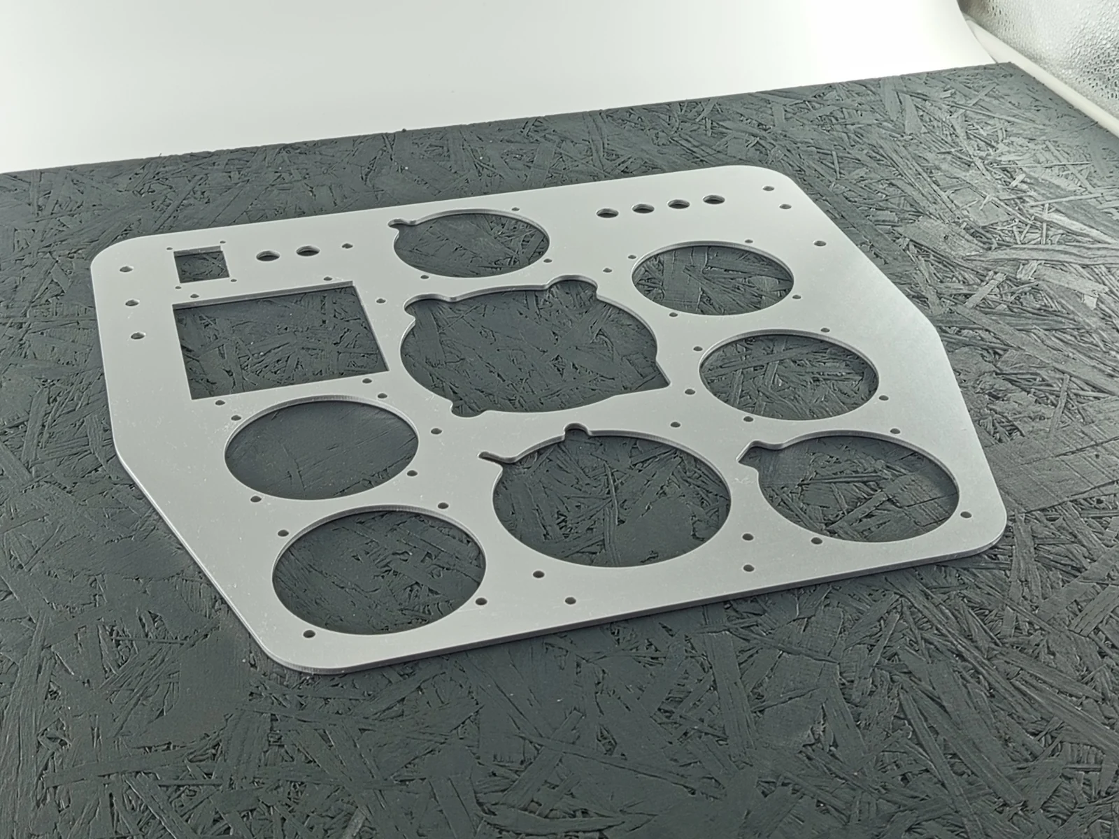 CNC-gefräste Frontplatte aus Aluminium 5083, 3mm dick, mit vielen runden und eckigen Aussparungen sowie kleinen Bohrungen.
