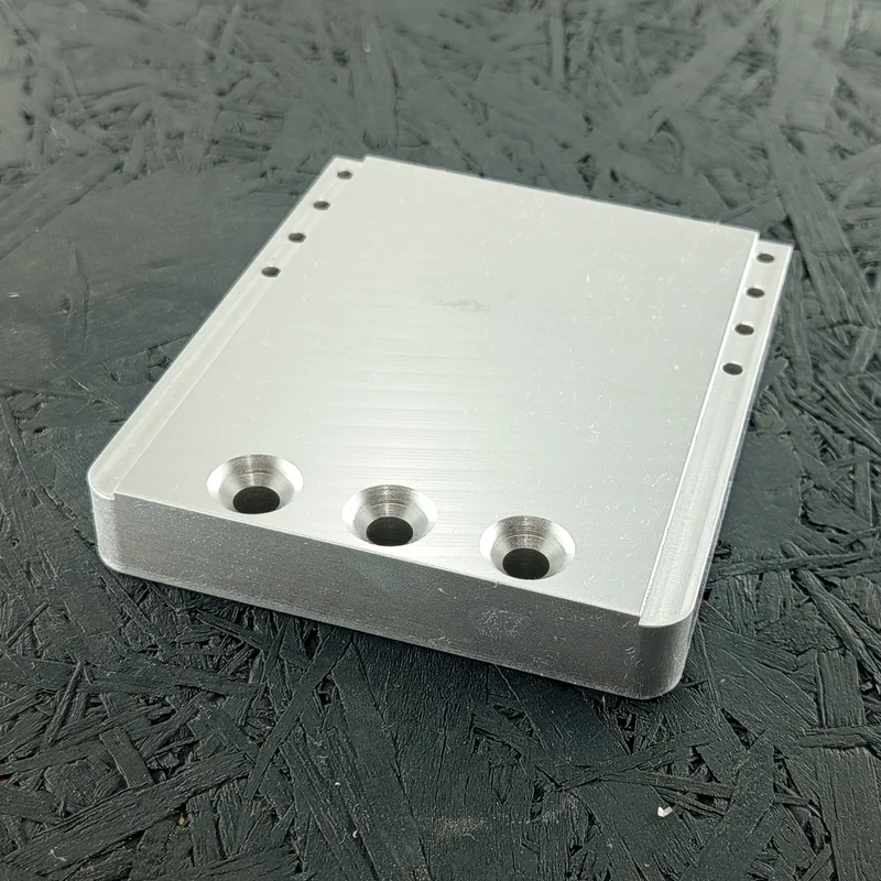 CNC-gefrästes Maschinenbauteil aus Alu 7075, 20mm dick, mit Senkungen und Bohrungen.