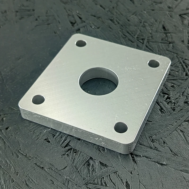 CNC-gefräste Adapterplatte aus Aluminium 5083, 10mm dick, mit zentraler Bohrung und vier Eckbohrungen.