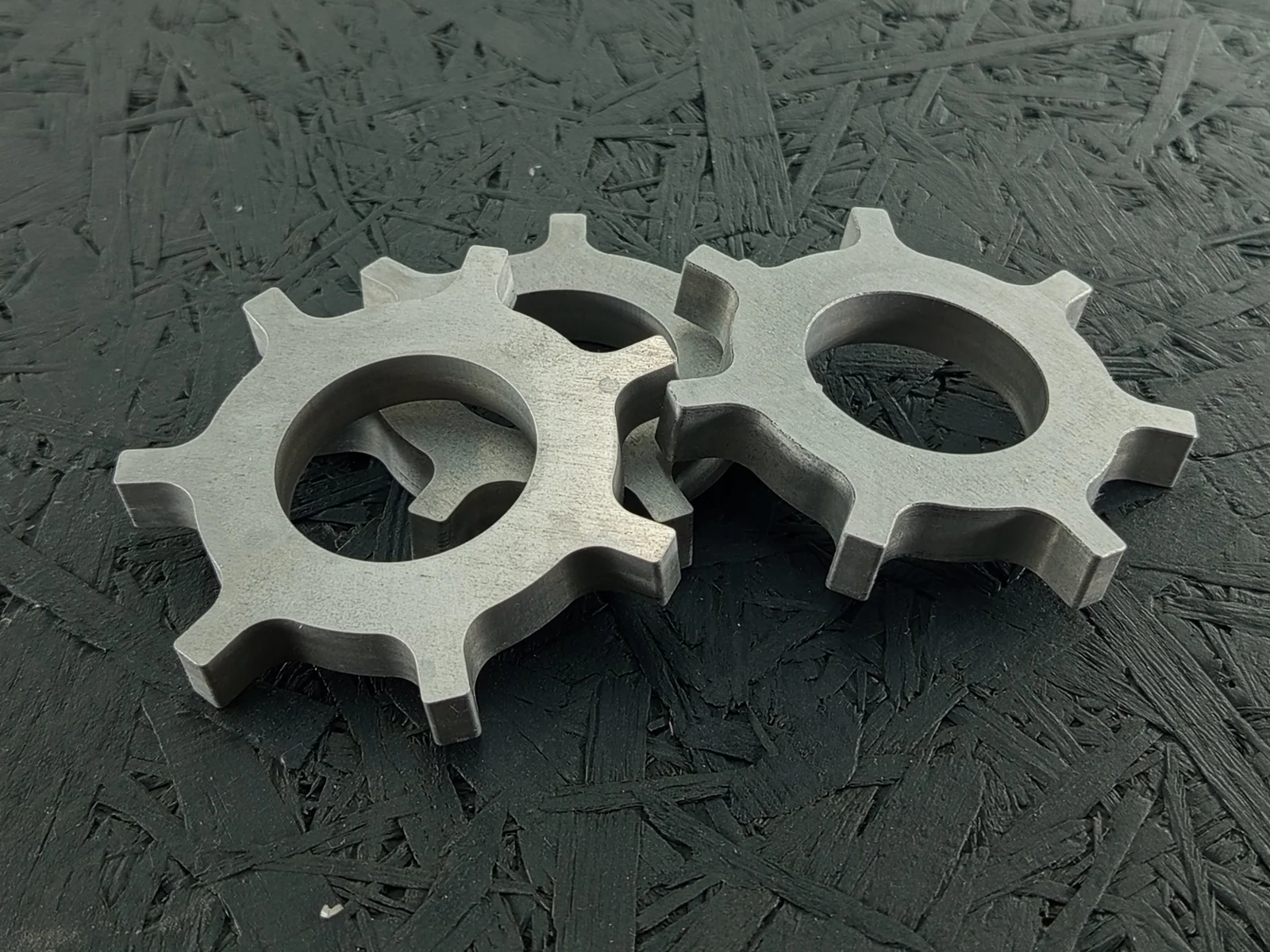 Bild eines CNC-gefrästen Maschinenbauteils aus Aluminium 7075 mit komplexer Außenkontur, zentraler Bohrung und Fasen, 10mm dick.